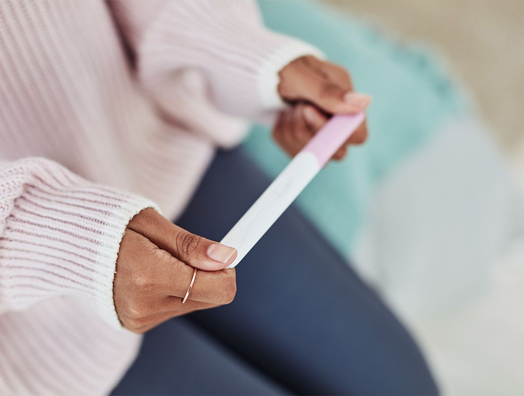 Frau hält Schwangerschaftstest