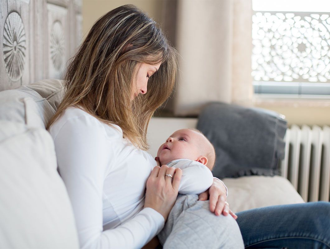 Frau hält Baby im Arm - Bifidusflora bei Säuglingen