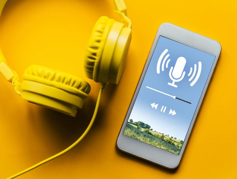 Kopfhörer und Handy mit Anzeige eines Podcasts