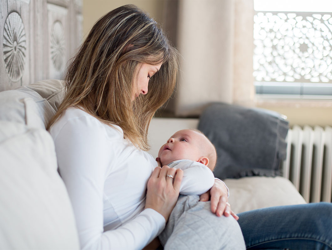 Frau hält Baby im Arm - Bifidusflora bei Säuglingen